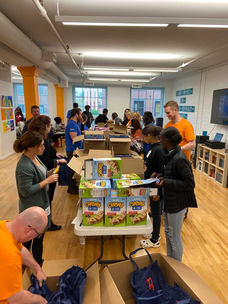 Group of volunteers assembling boxes of supplies indoors