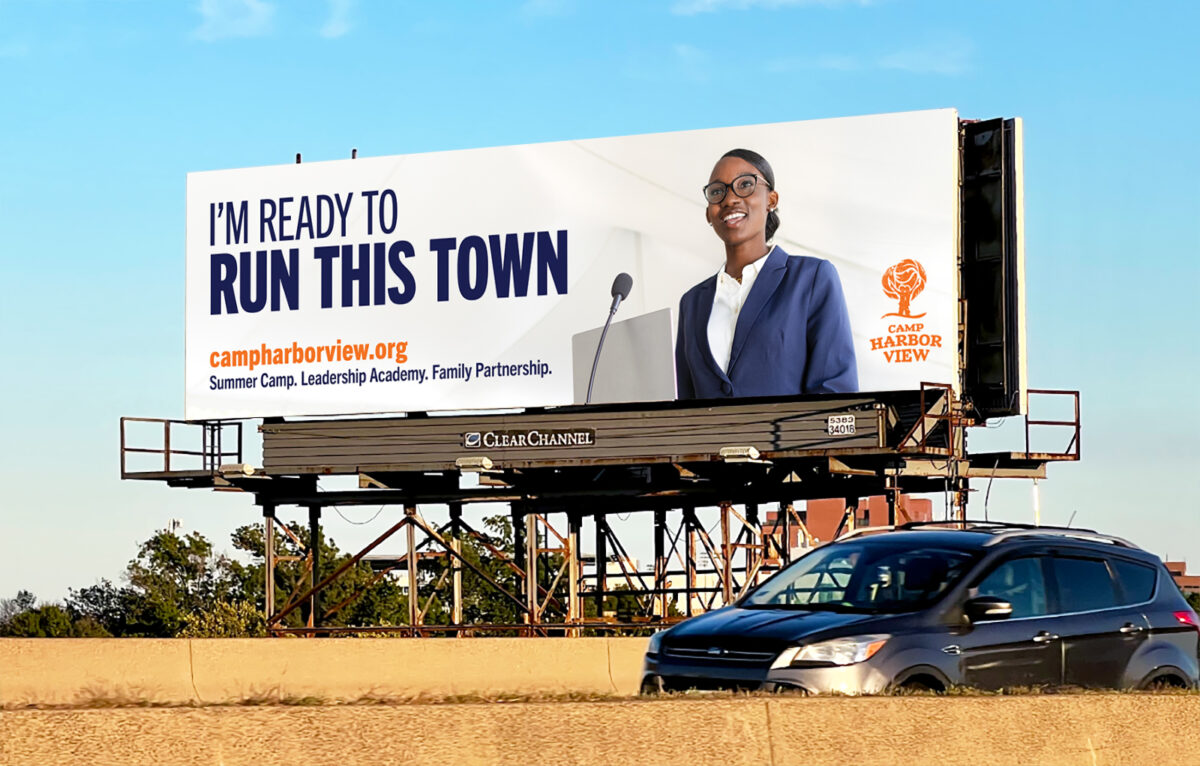 Photo of a Camp Harbor View billboard on route 93 in Boston that says "I'M READY TO RUN THIS TOWN" with an image of a teen speaking at a podium wearing a blazer.