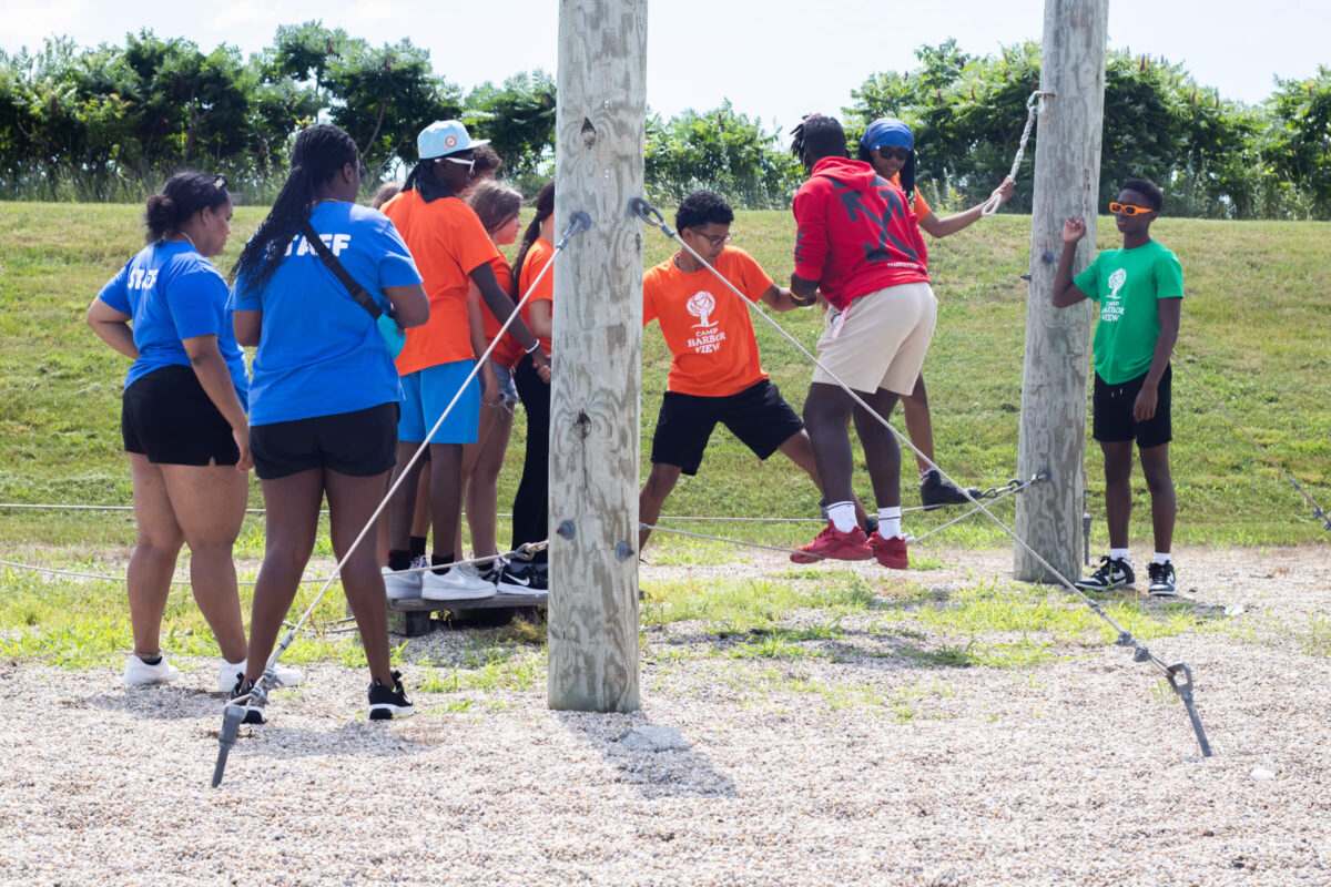 Campers doing a teambuilding activity at the ropes course