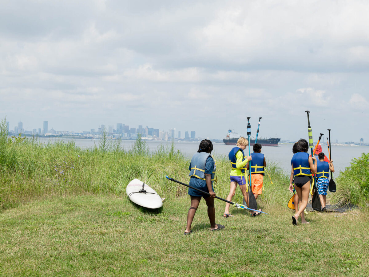 Campers walking with paddleboard equipment
