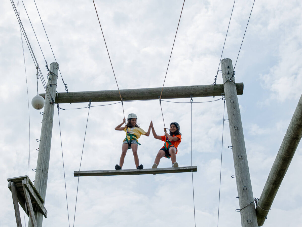 Campers high-five on ropes course