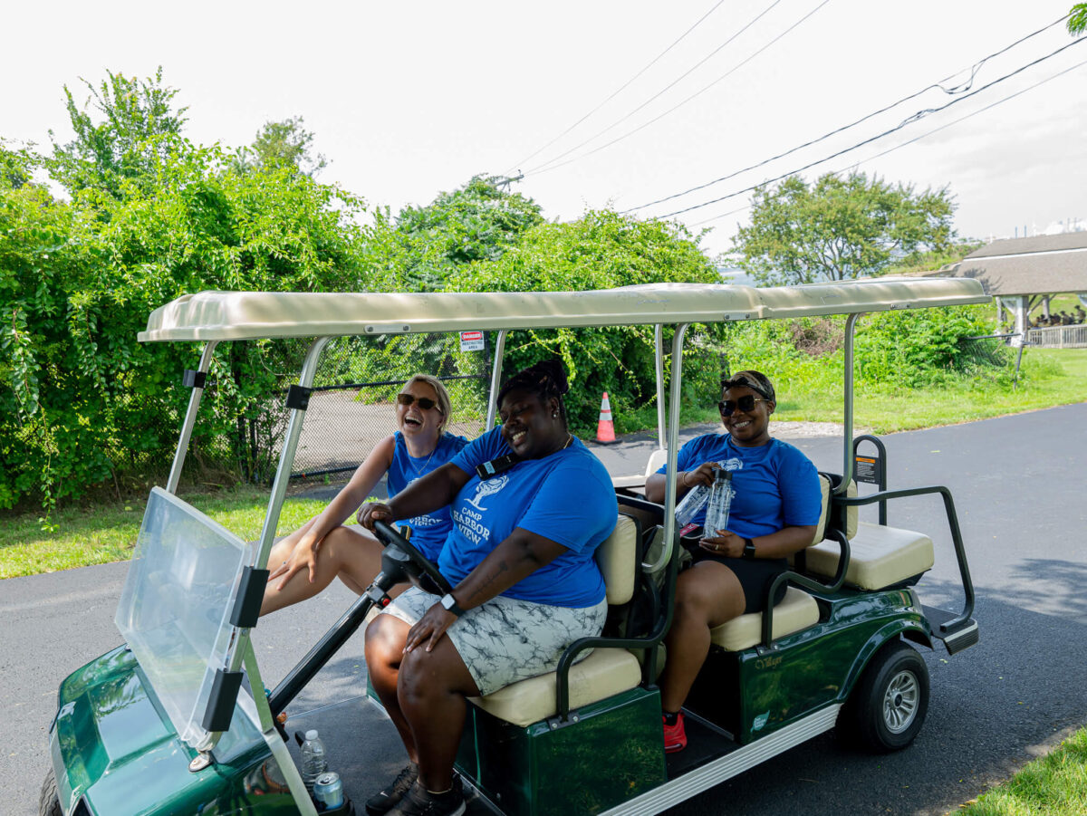 Staff smiling together in golf cart