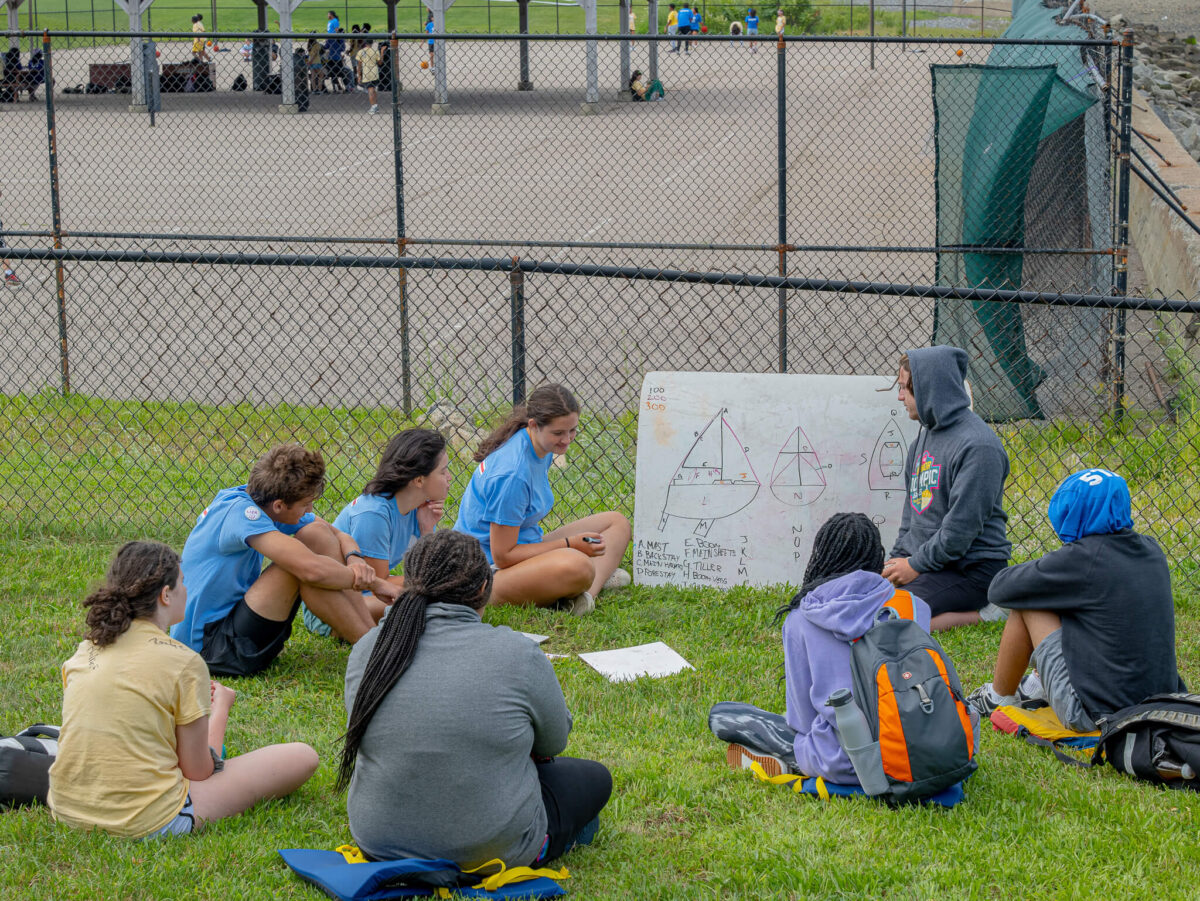 Campers sitting in the field while learning sailing vocab