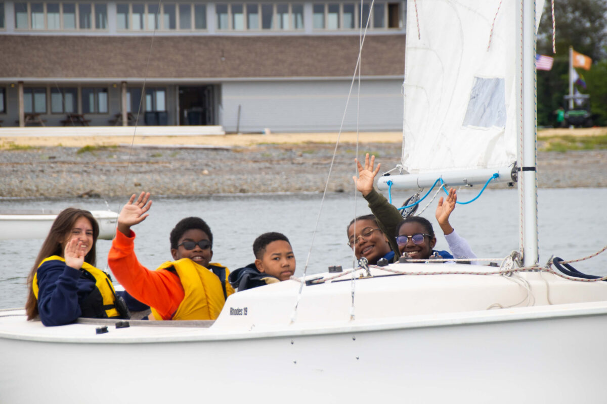 Campers waving in sailboat