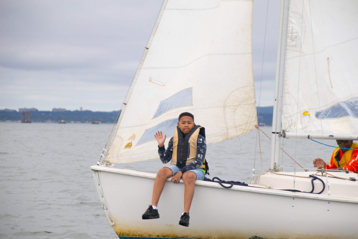 Camper waving in sailboat