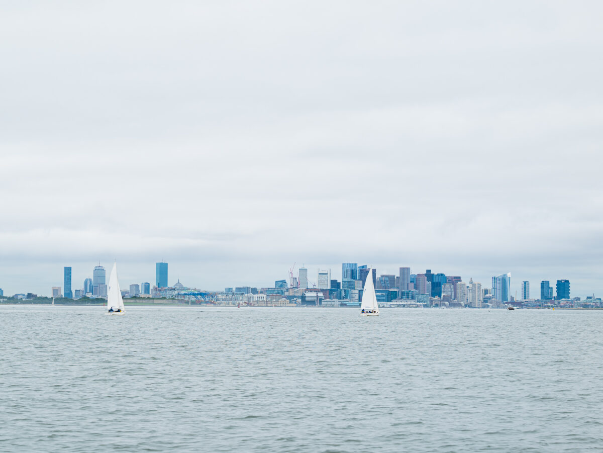 Campers sailing in front of Boston skyline