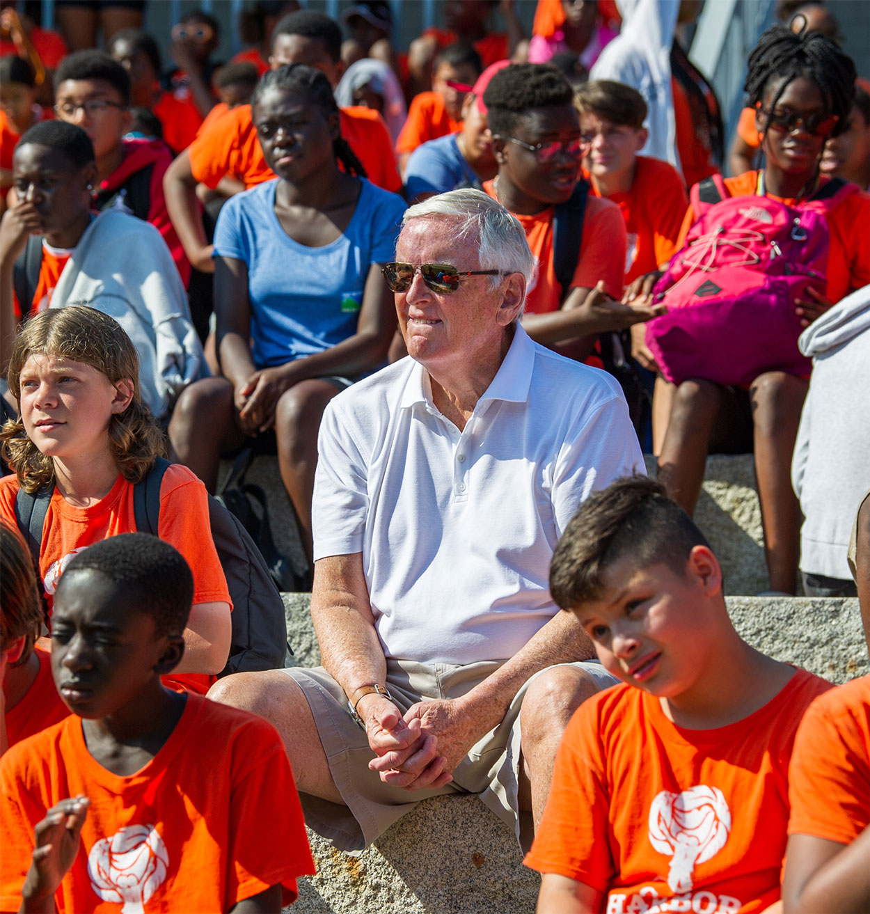 Jack Connors sitting with campers in the amphitheater at Camp Harbor View