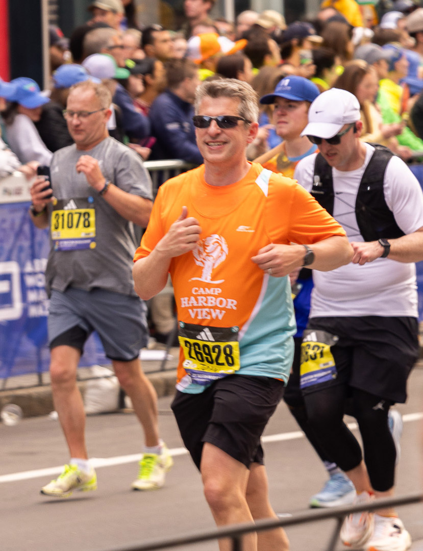 Boston Marathon runner wearing an orange Camp Harbor View shirt