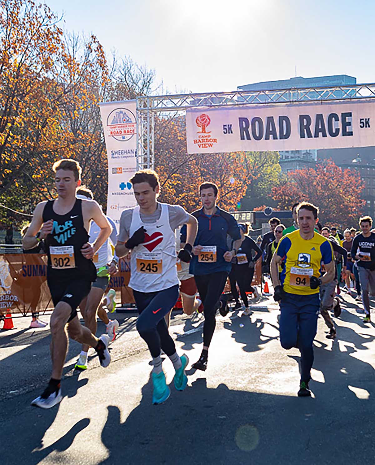 Runners taking off from the Camp Harbor View 5K Road Race start line on the Boston Common